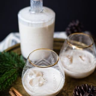 bottle of eggnog with two glasses