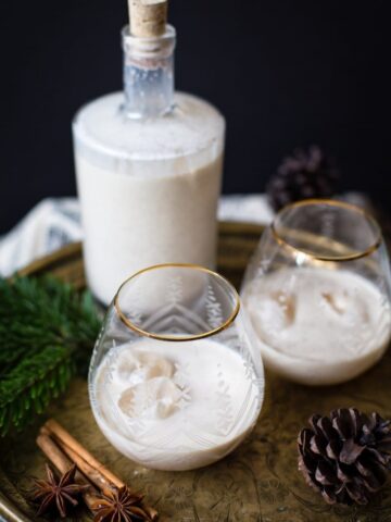 bottle of eggnog with two glasses