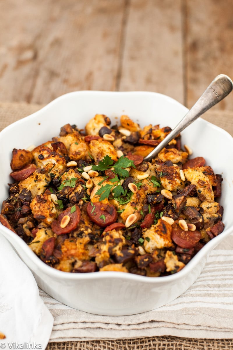 Side shot of stuffing in white dish on wooden surface