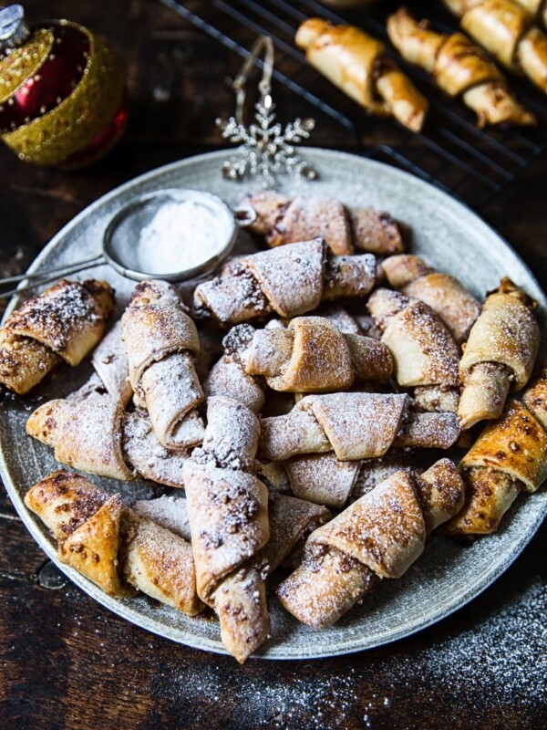 Rugalech on a plate with sugar and more in the background on cooling rack