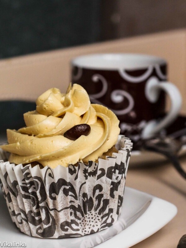 Close-up of a cupcake with coffee in the background