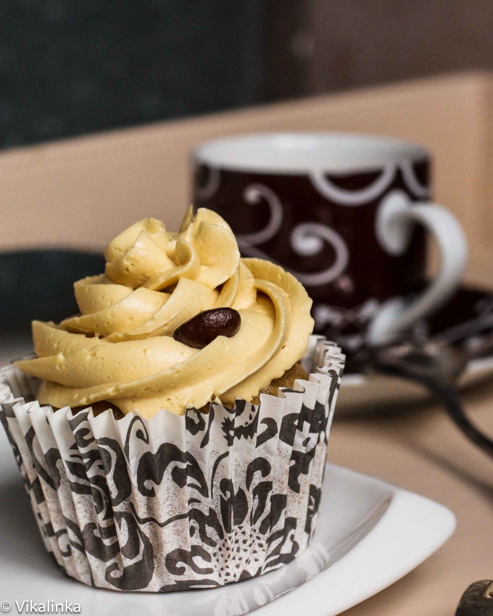 Close-up of a cupcake with coffee in the background