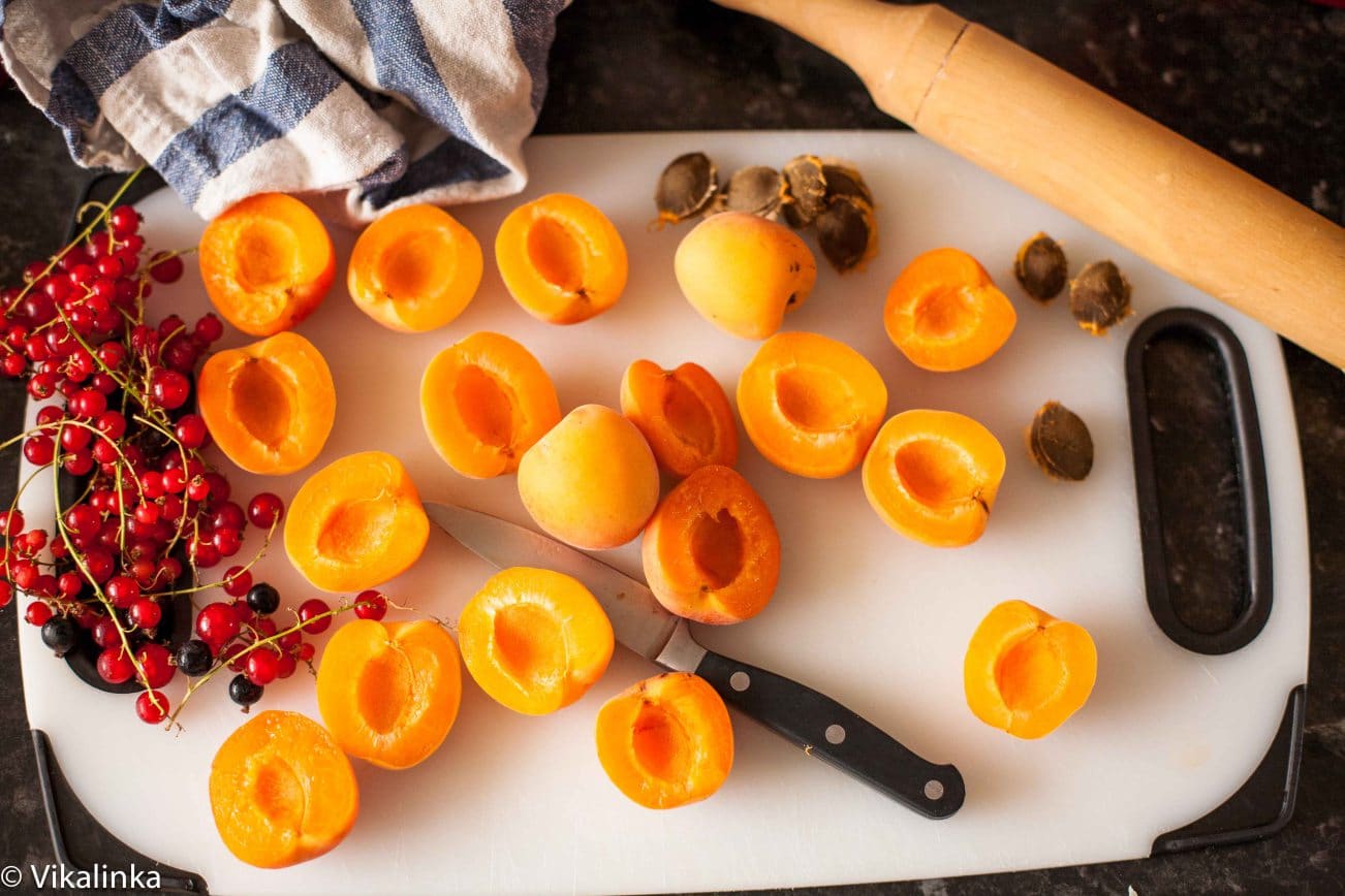 Sliced apricots on a white cutting board