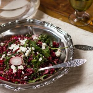 Side shot of beet and quinoa salad in silver bowl with a spoon