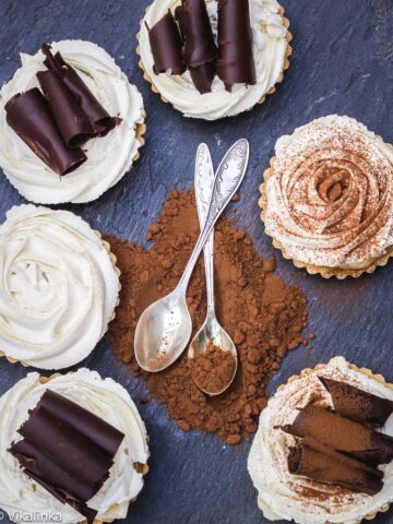 Top down of tarts in a circle with chocolate and spoons at the centre