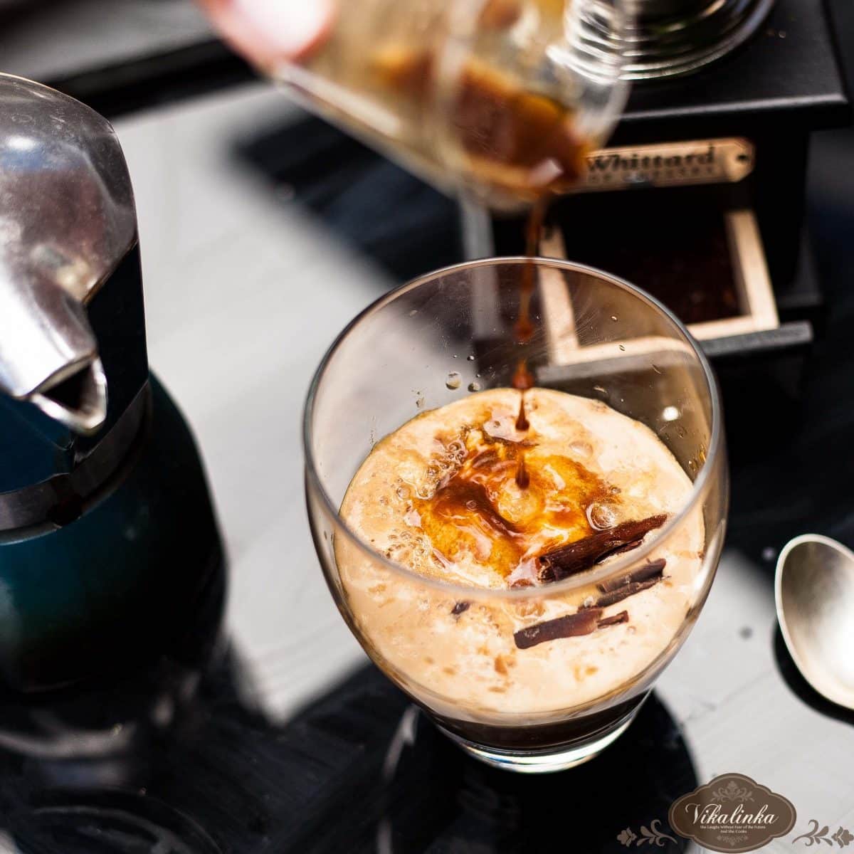 Close up of salted caramel affogato being poured into a clear glass