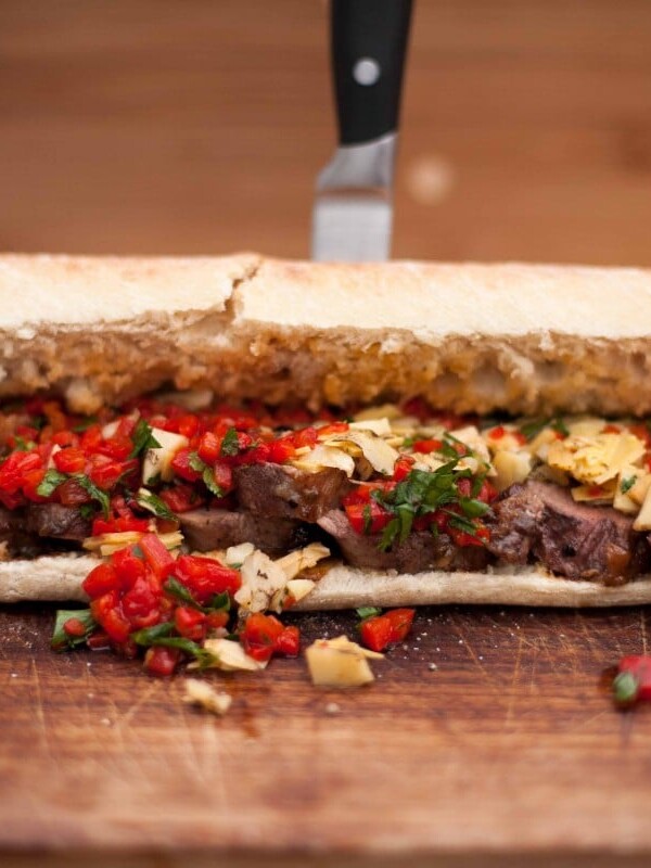 Close up of duck breast sandwich with knife in background