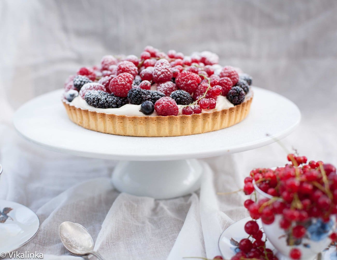 Shot of tart on stand with cranberries in the front