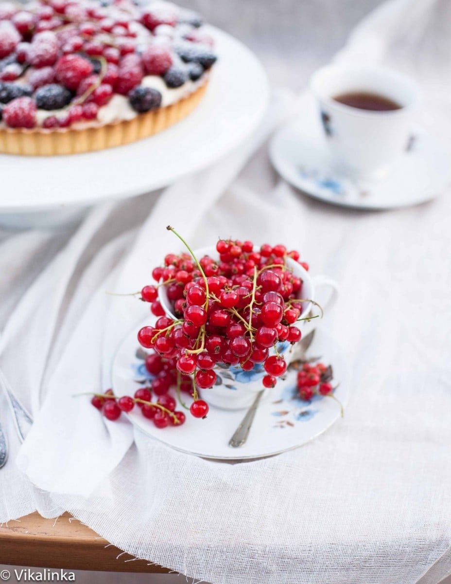 Close up of cranberries and tea cup with bake in background