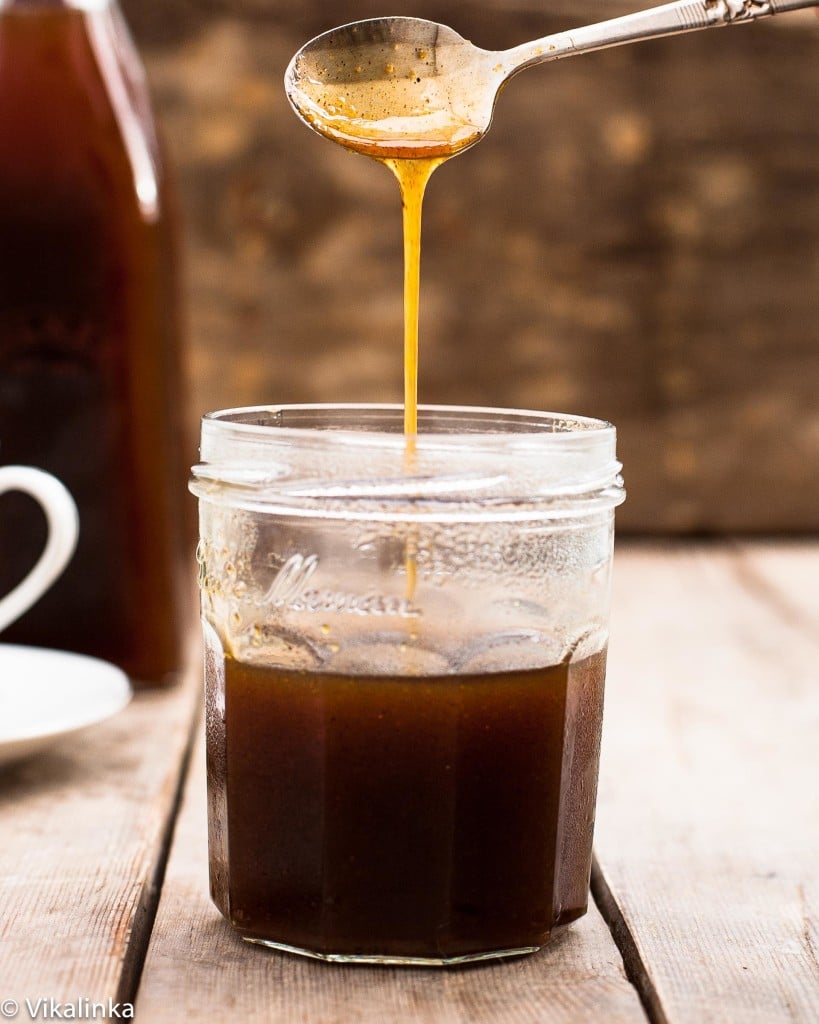 Spoon pouring pumpkin spice syrup into a jar