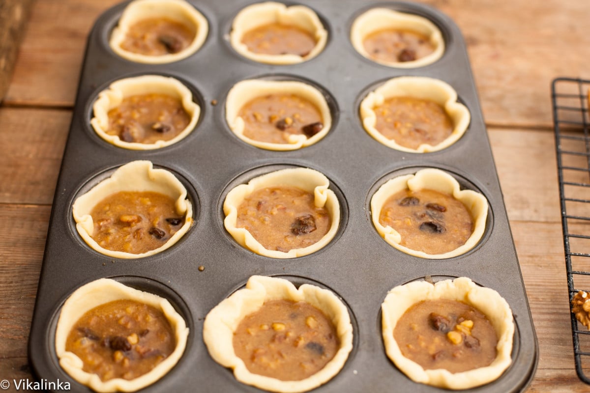 unbaked butter tarts in a baking pan