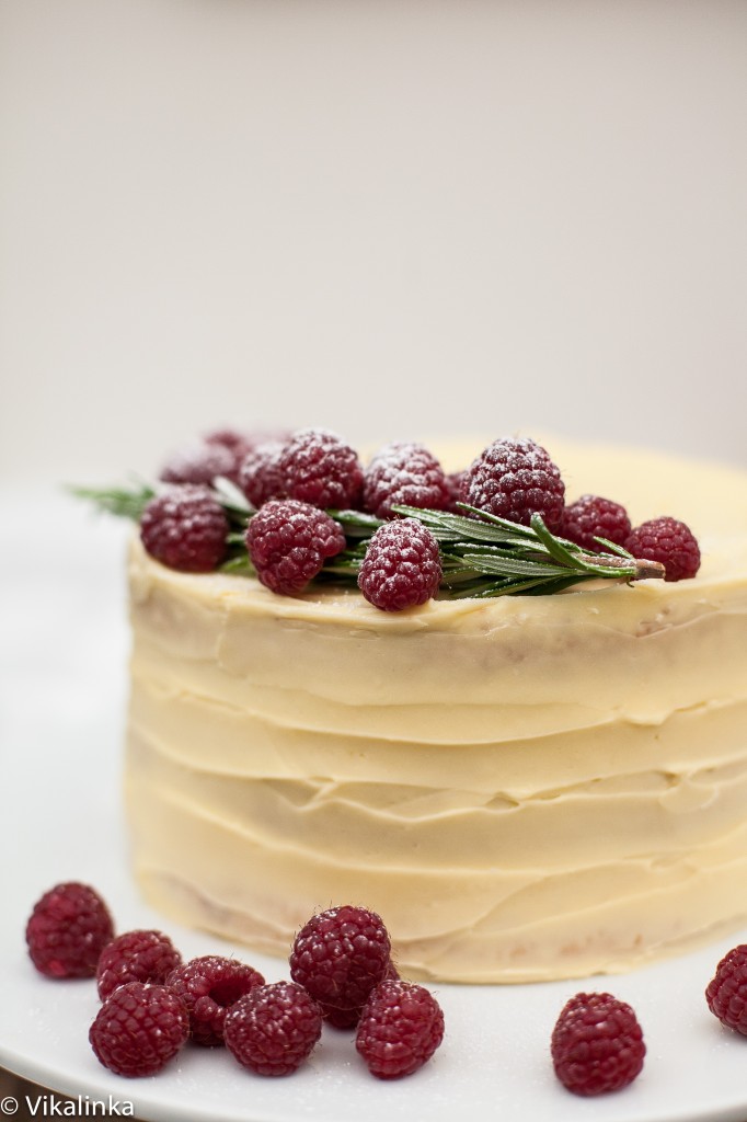 Side view of the cake with heaped raspberries.