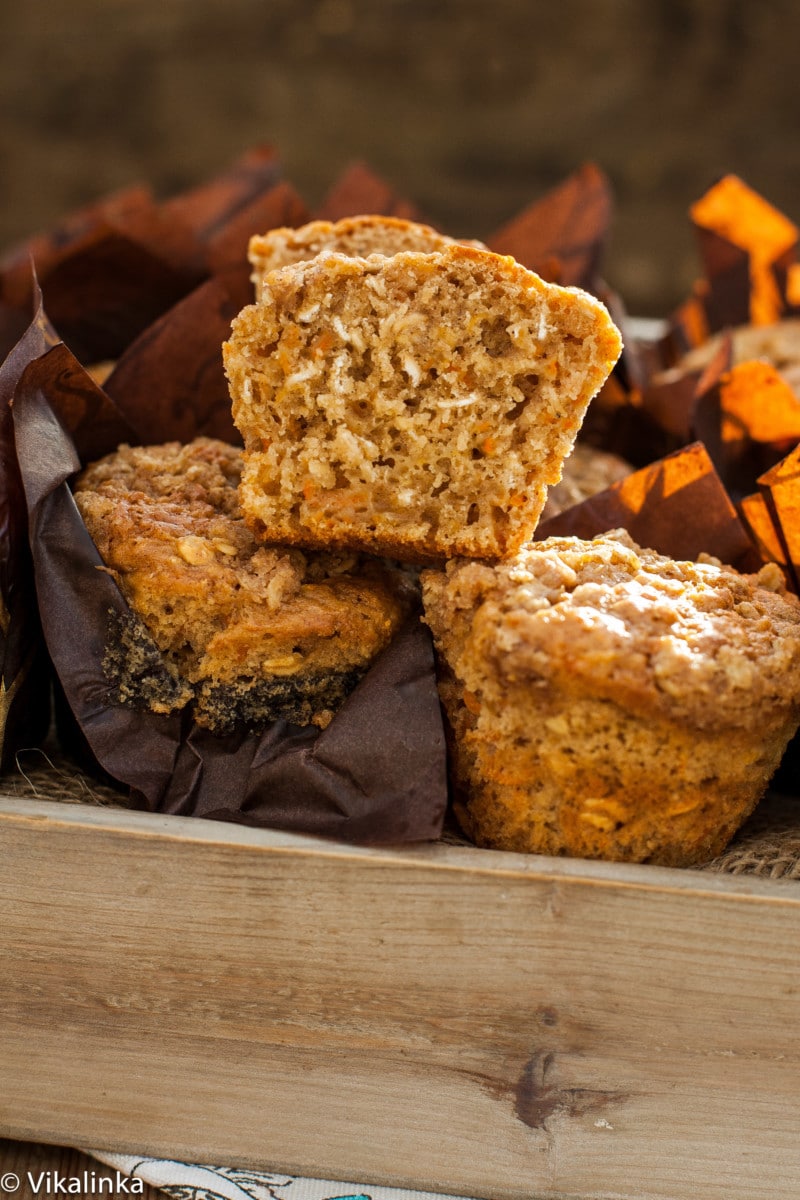 muffins in a bread box, one muffin is cut in half, so the crumb is showing