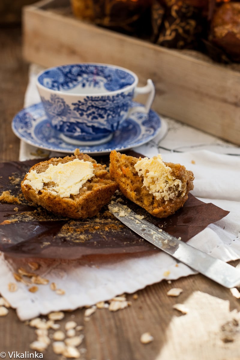 muffin cut in half and spread with butter, blue teacup in the background