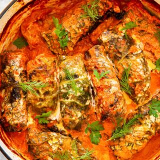 cabbage rolls in creamy tomato sauce in orange pot