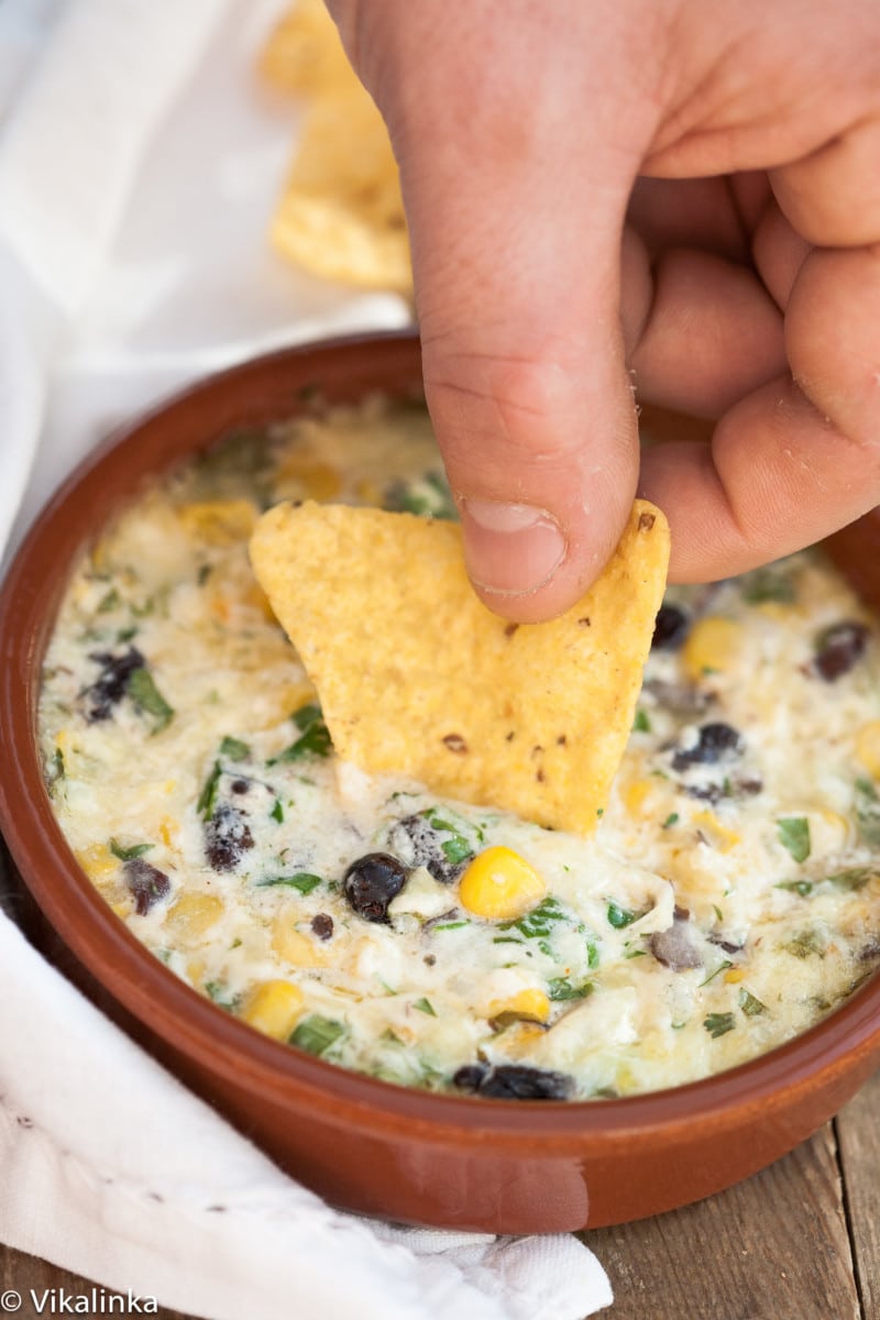 a chip being dipped in a cheesy cheddar southwest dip