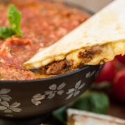 quesadilla being dipped in salsa