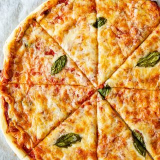 Top down view of puff pastry pizza margherita on a baking tray