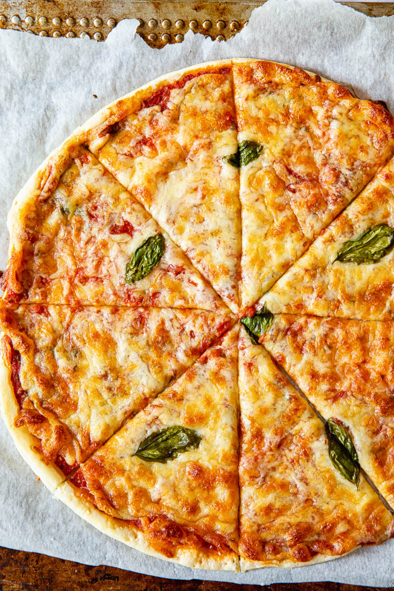 Top down view of puff pastry pizza margherita on a baking tray