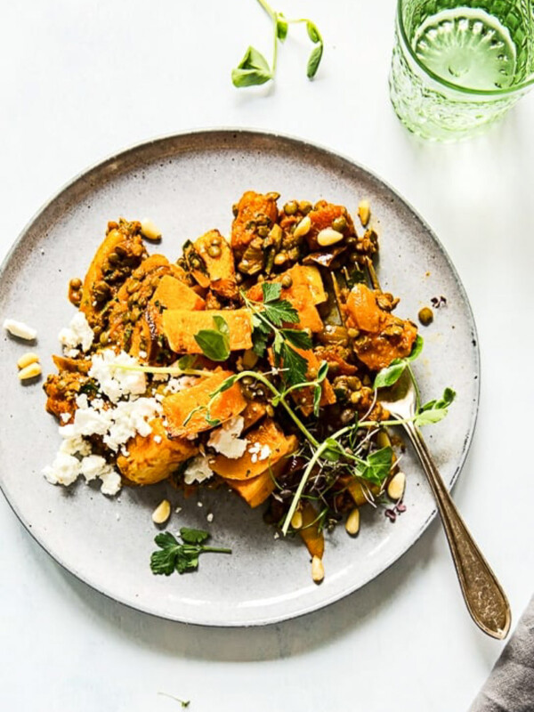 top down view of roasted squash, lentils and feta on grey plate