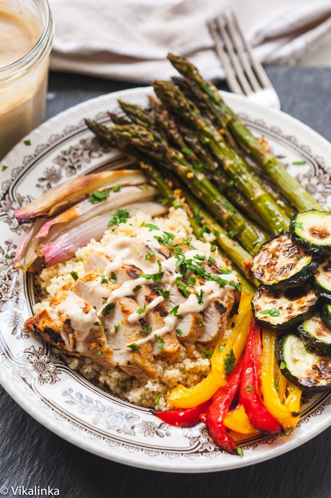 Mediterranean couscous bowl in small dish showing spread of ingredients including Moroccan chicken