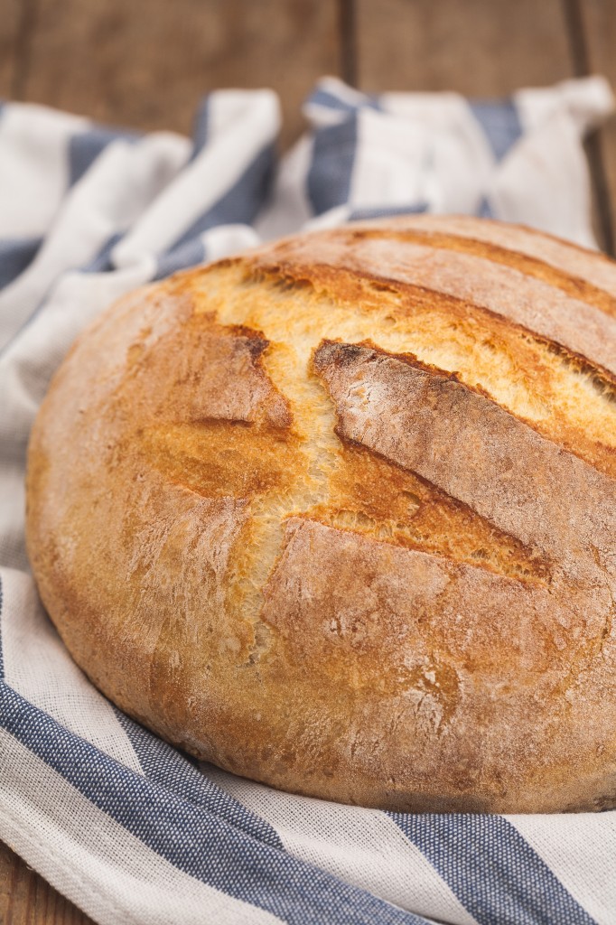 A loaf of dutch oven bread on a towel