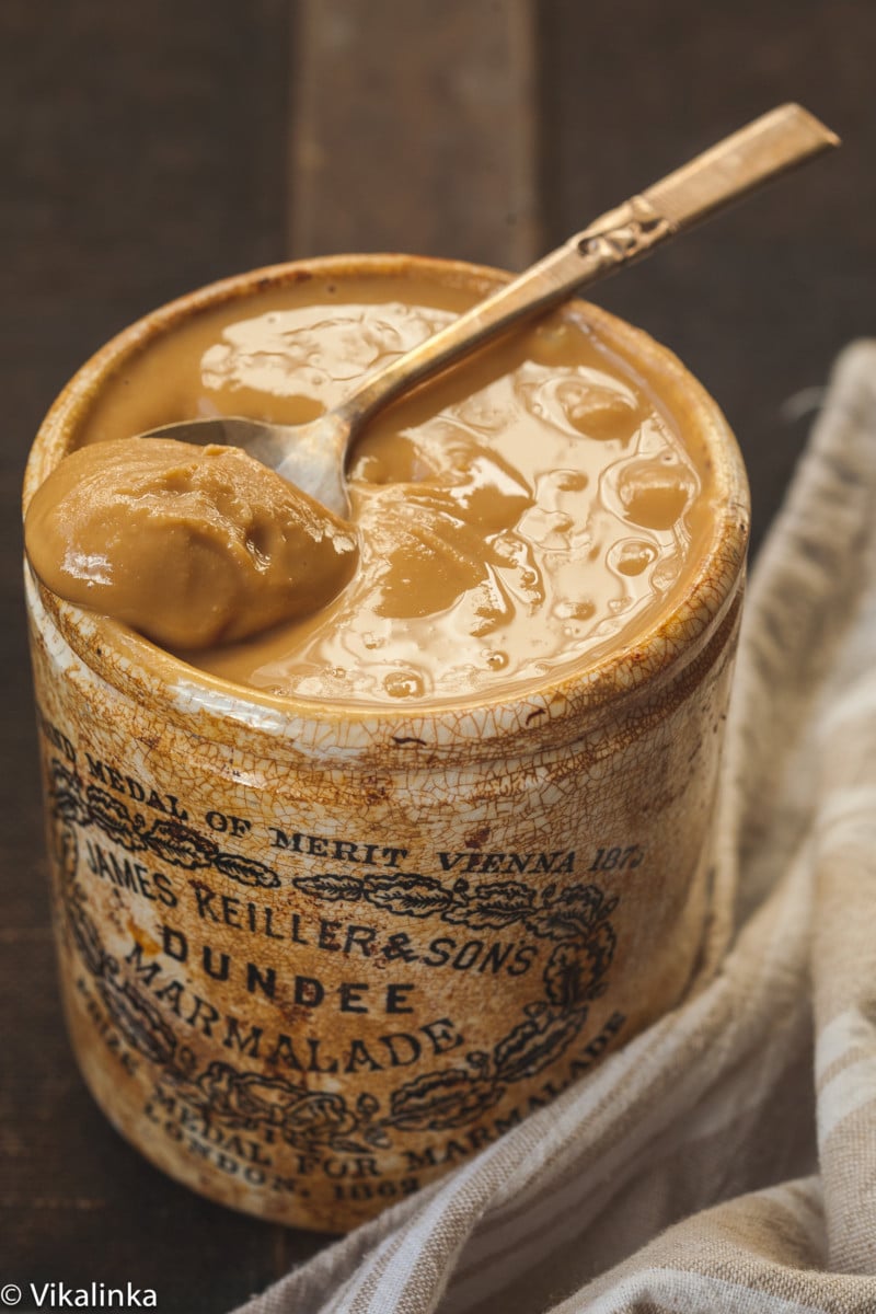 peanut butter in a brown jar with a spoon in it