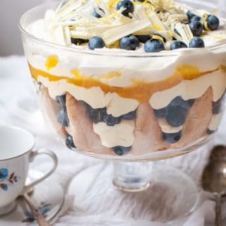 Blueberry Lemon Trifle on a table covered with white cloth and a white and blue teacup