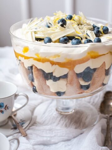Blueberry Lemon Trifle on a table covered with white cloth and a white and blue teacup
