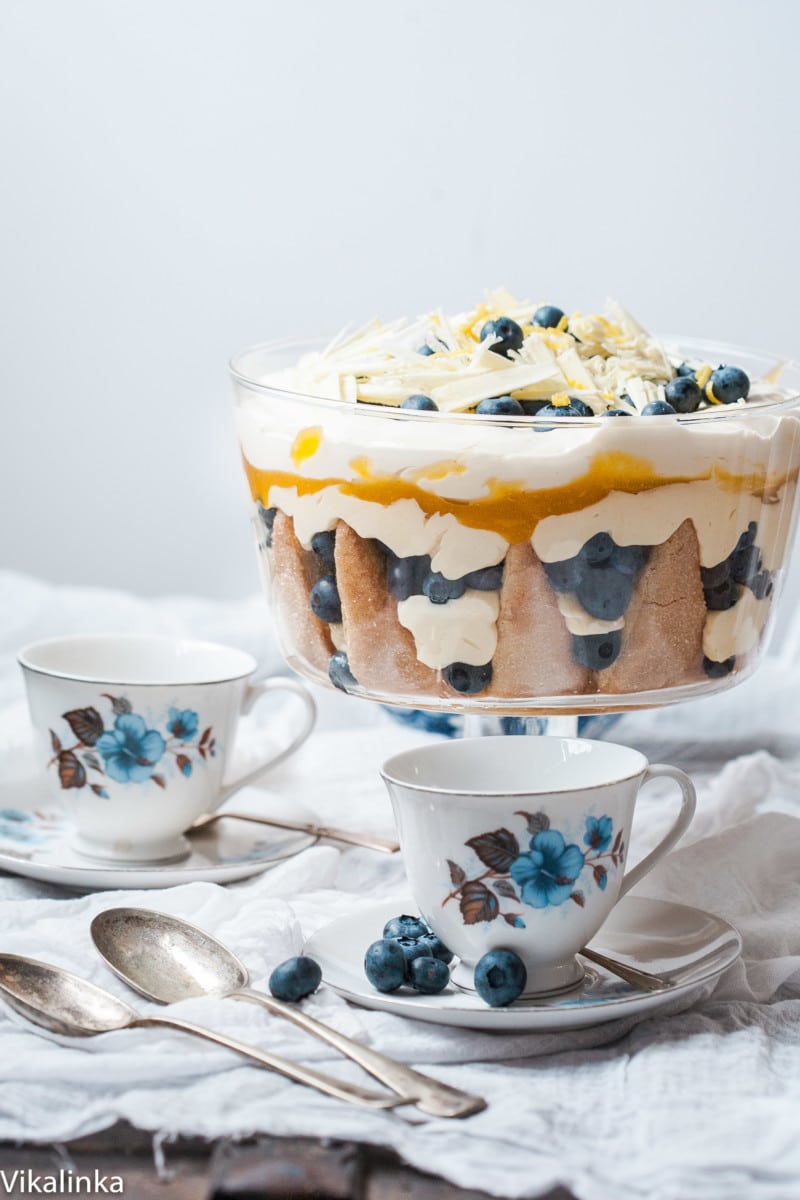 blueberry trifle on table, two white and blue teacups