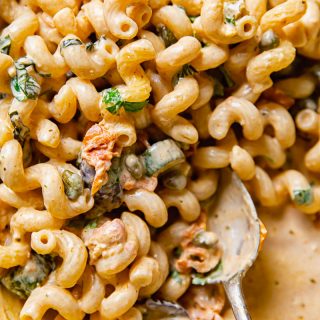 Close up of Mediterranean pasta with zucchini with a serving spoon