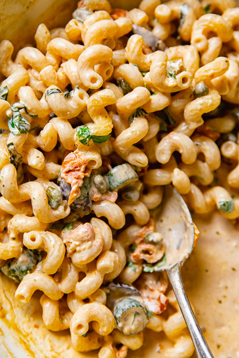 Close up of Mediterranean pasta with zucchini with a serving spoon