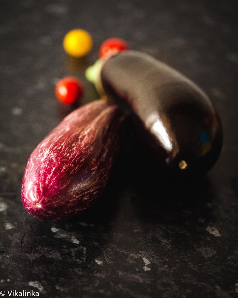two eggplants on dark background.