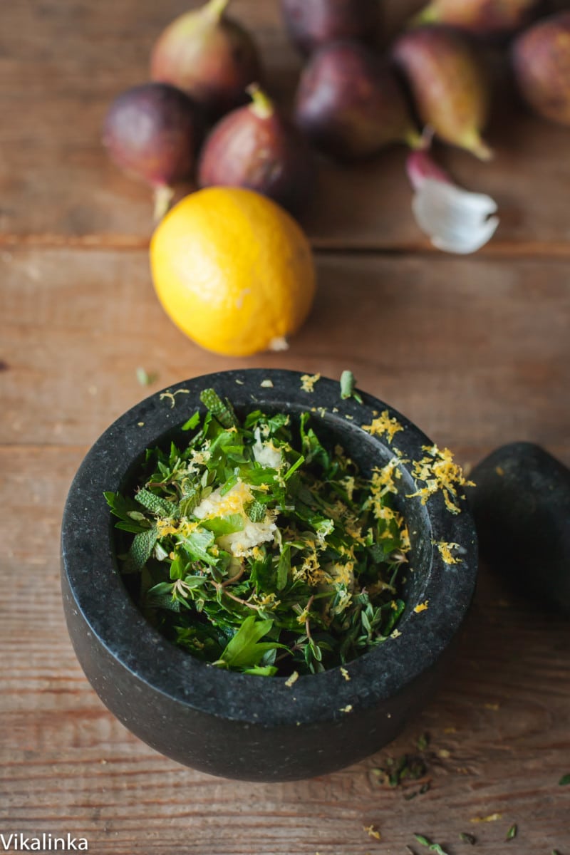 chopped herbs and lemon zest in mortar and pestle