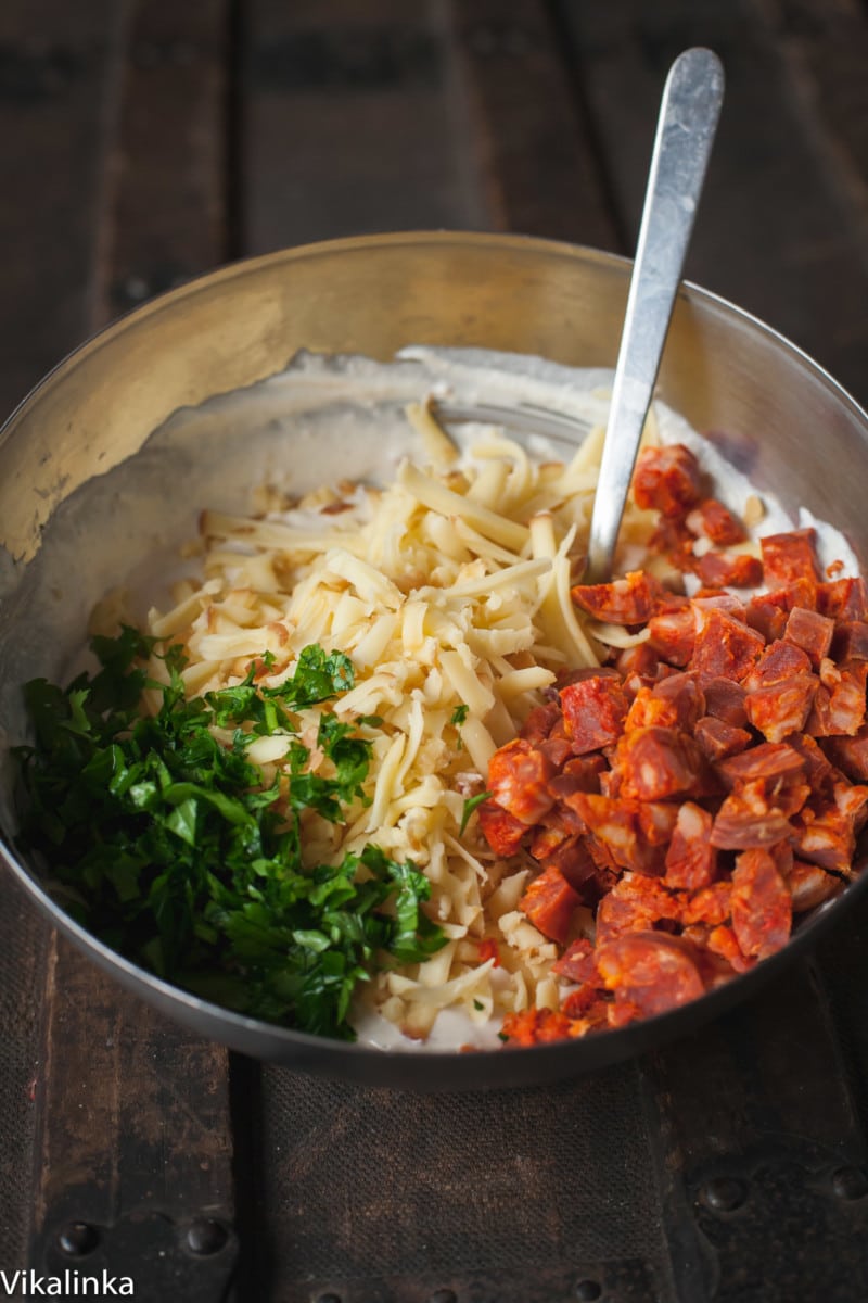 grated cheese, chopped chorizo and parsley in a bowl