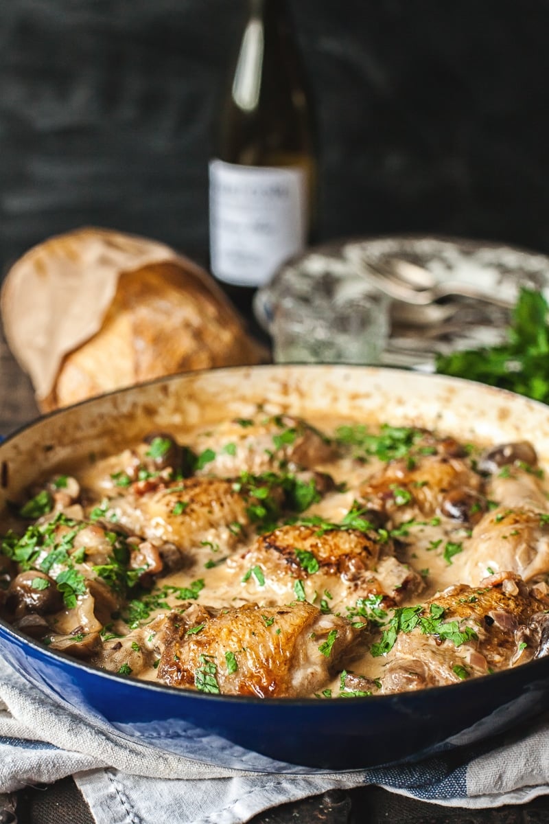 Coq au Chardonnay in a pan with bread in the background