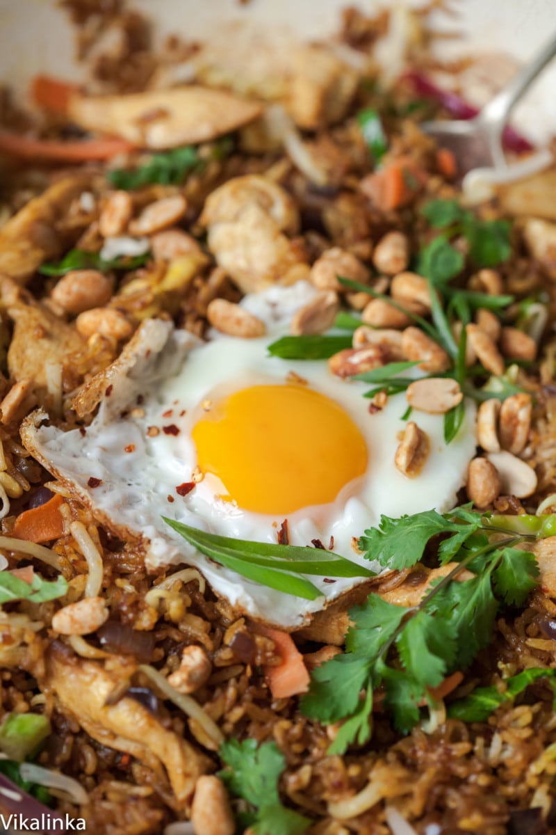 Close up of fried egg with scattered peanuts on rice