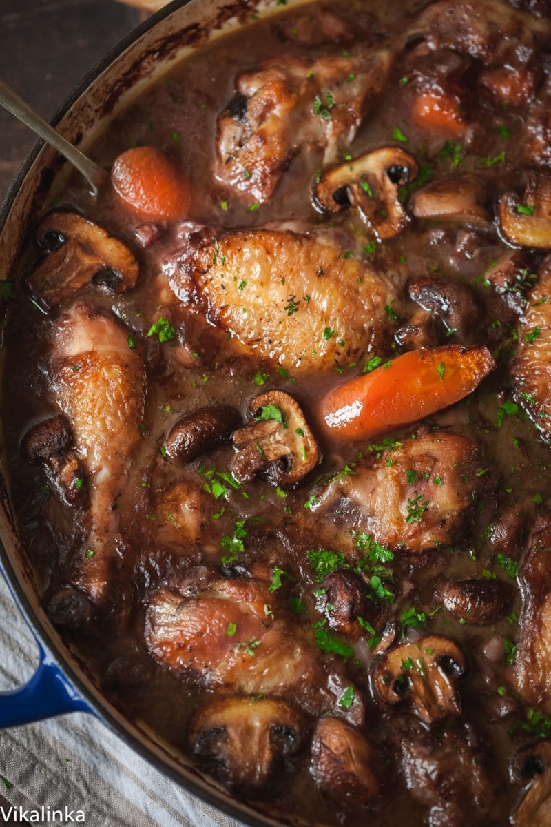 top down view of coq au vin with carrots and mushrooms