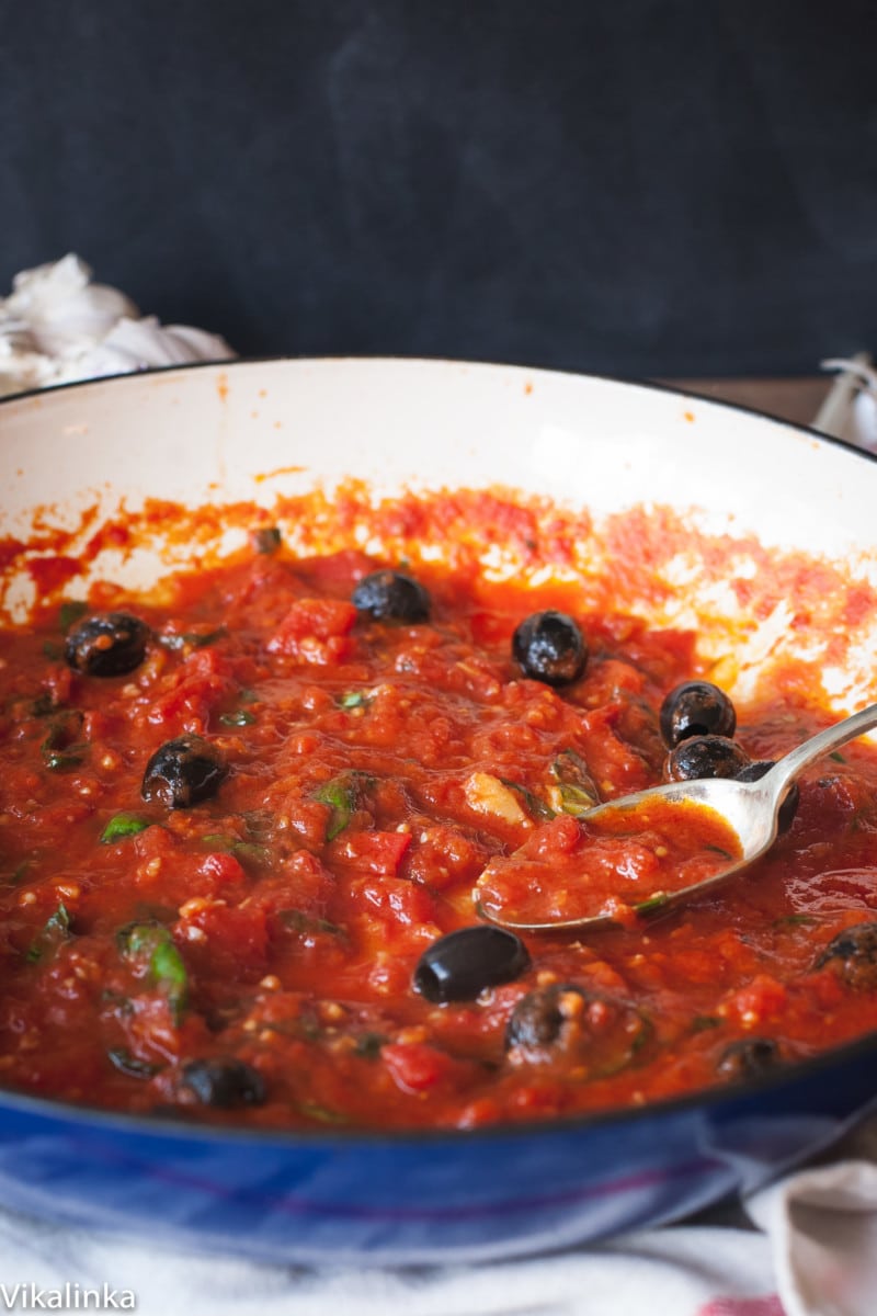 tomato sauce with black olives in a blue pan