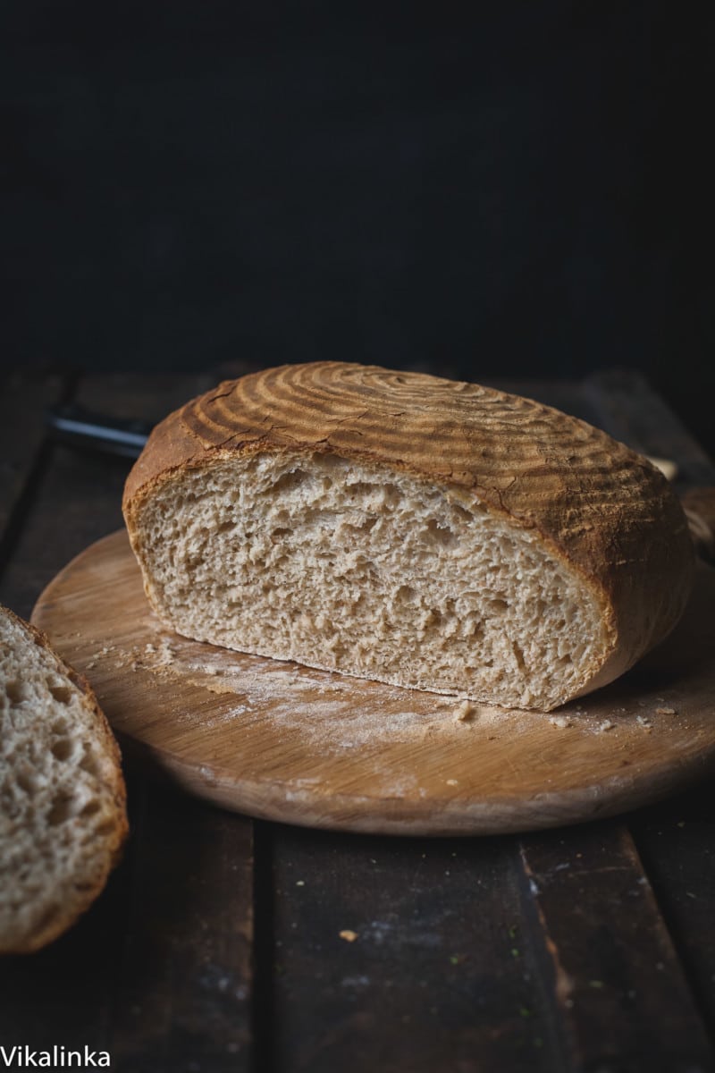 Loaf of bread on a cutting board with slice removed