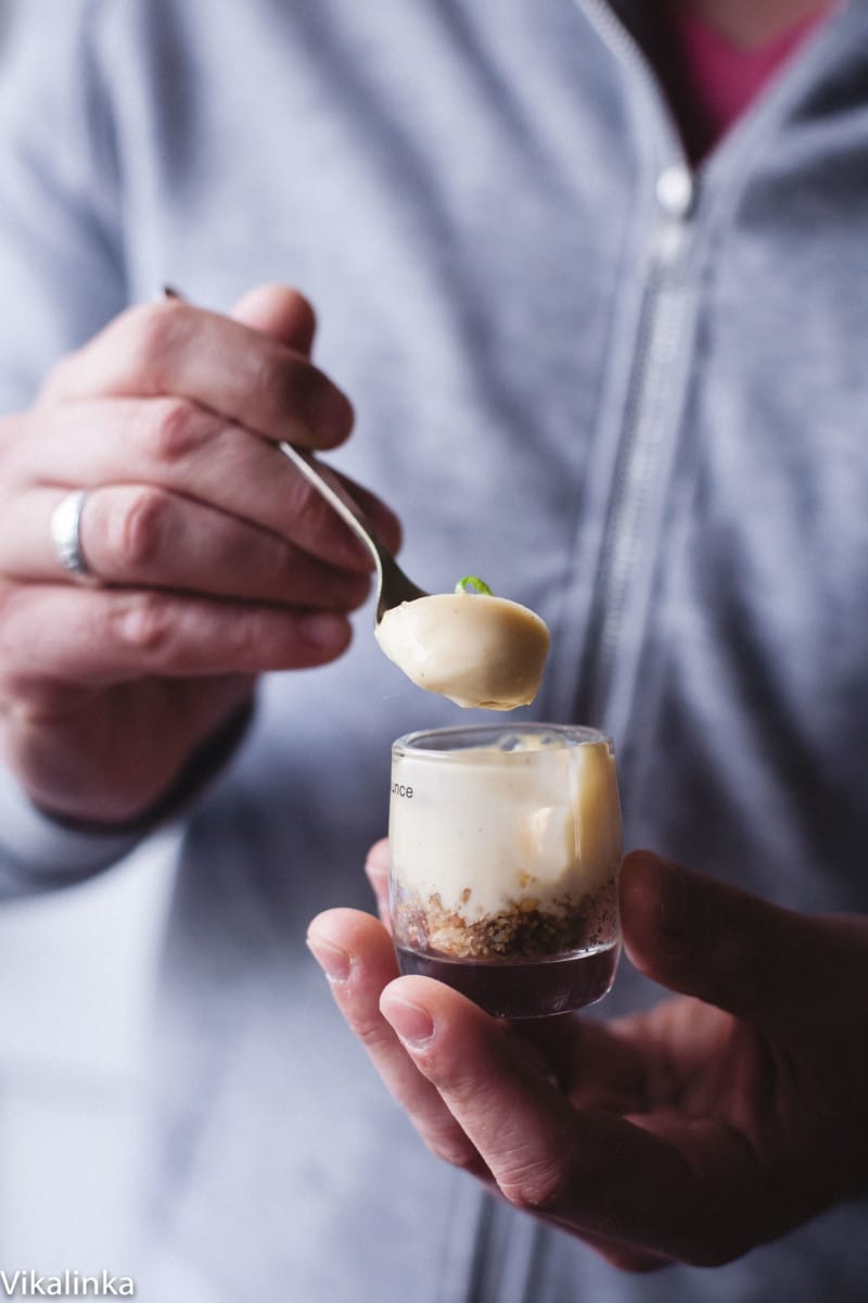 a person holding lemon posset in a shot glass