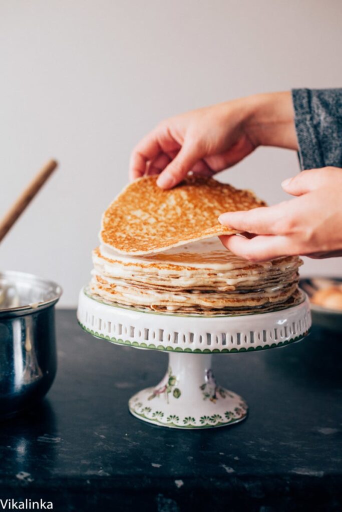 Two hands stacking pancakes