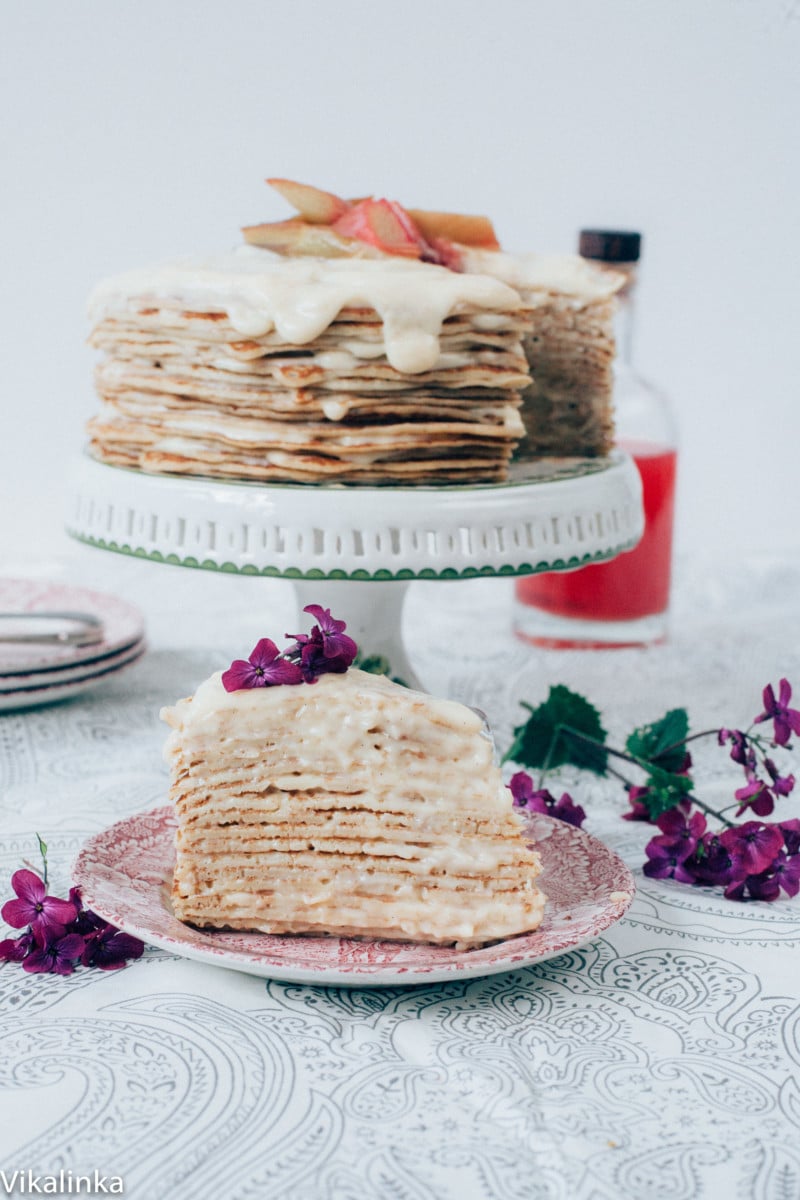 Piece of crepe cake with full cake in background