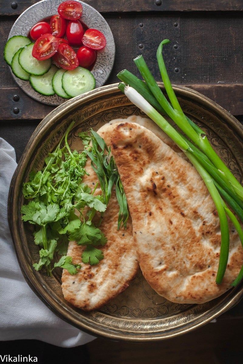 Top down shot of naan and greens on plate