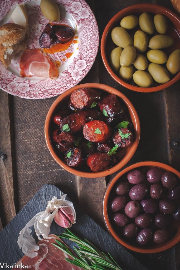 Chorizo in red wine with dishes of olives and other tapas