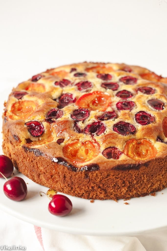 Side view of the cake on a stand with two cherries for decoration