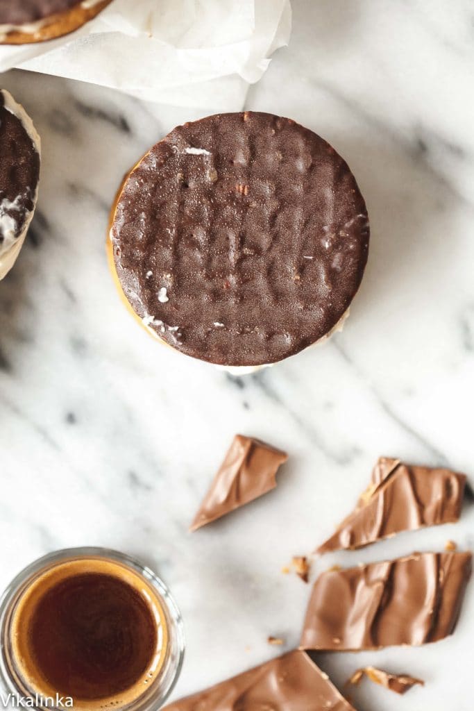 Top down view of an ice cream sandwich next to chopped daim bar and espresso shot