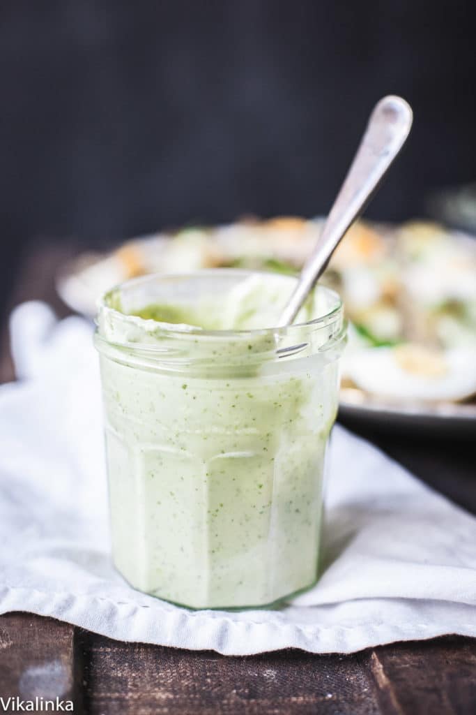 Jar of green goddess dressing with a spoon