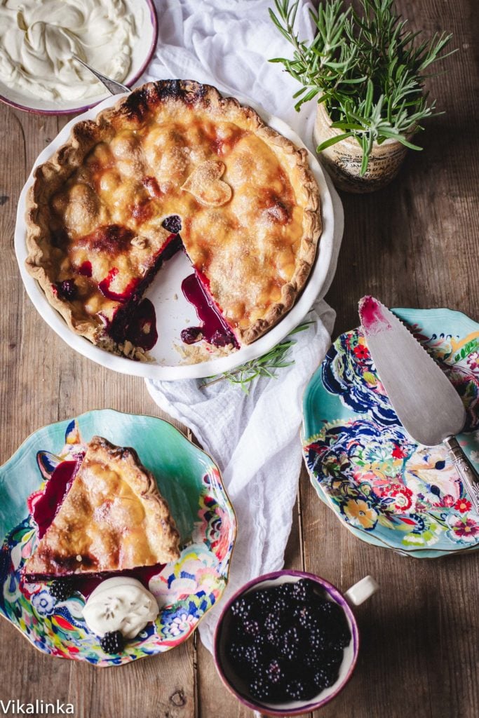 Top down view of blackberry pie with a piece cut out and on a separate plate