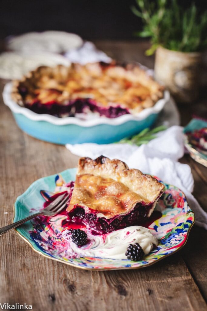 Piece of wild blackberry pie with dollop of creme fraiche